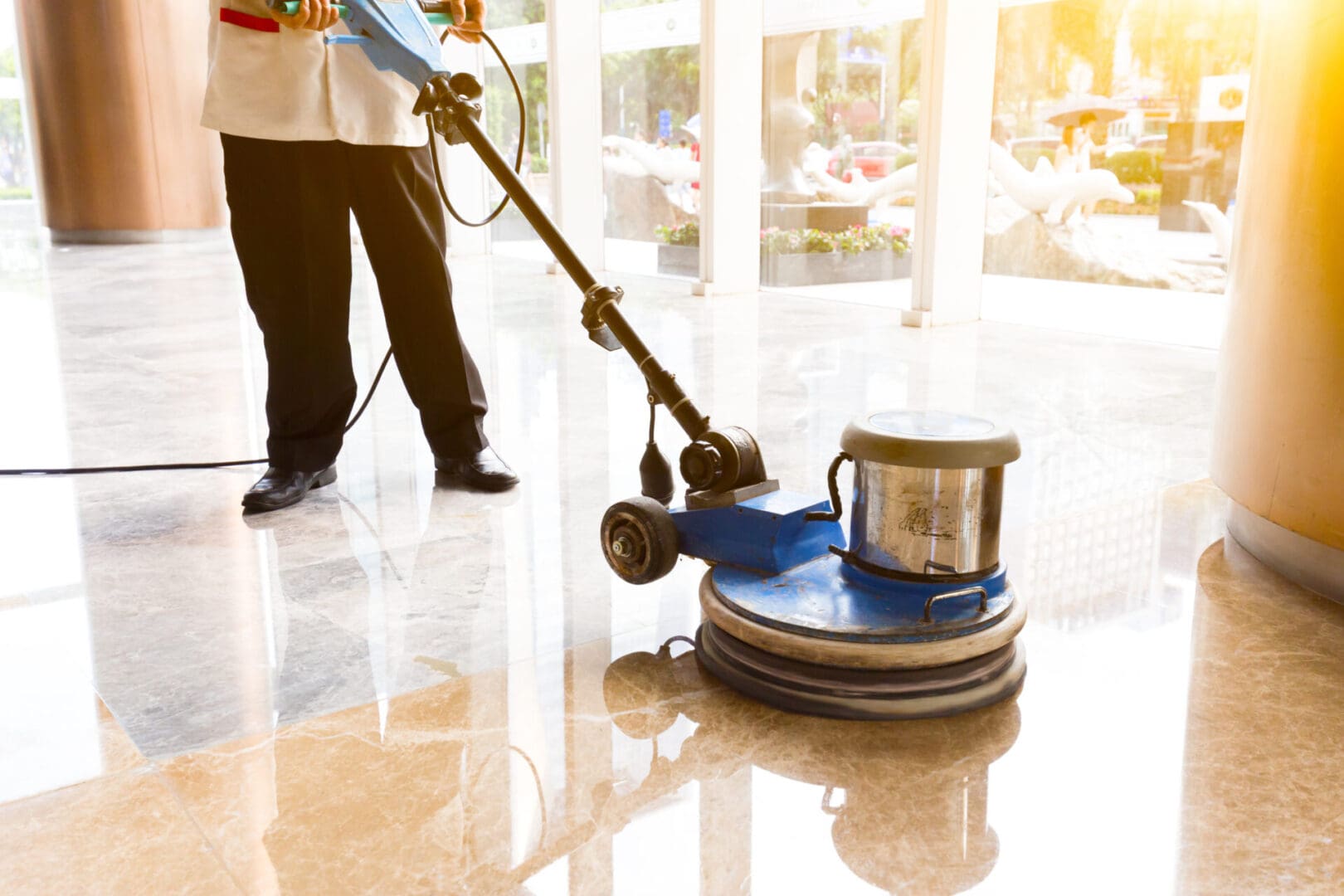 A man is cleaning the floor with a machine.