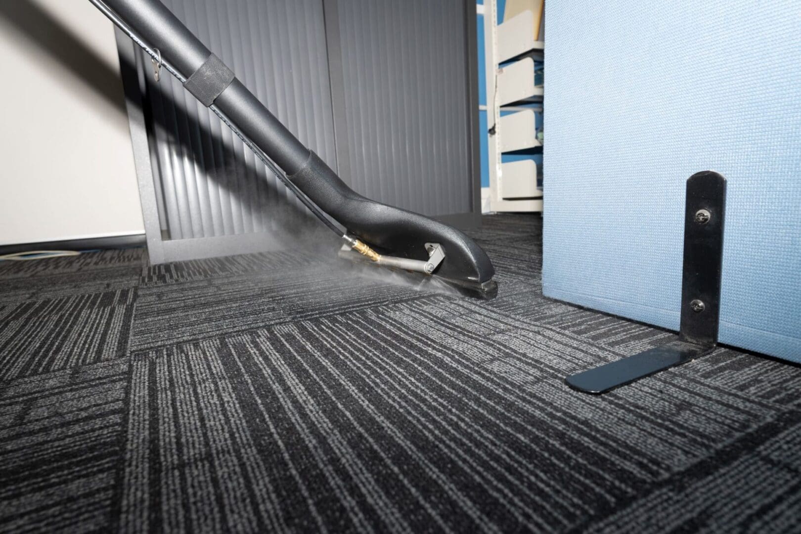 A carpet cleaning machine is spraying water on the floor.