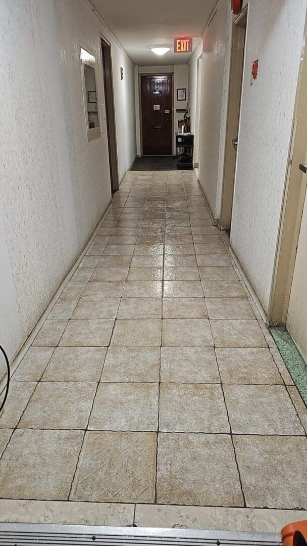 A hallway with tile floors and white walls.