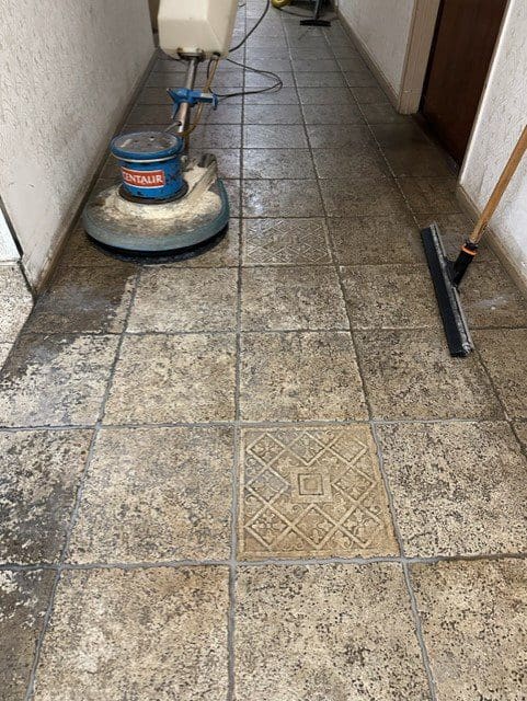 A tile floor being cleaned by a machine.